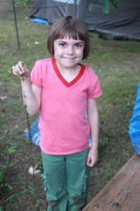 Abby and a long root she unearthed while digging in the dirt